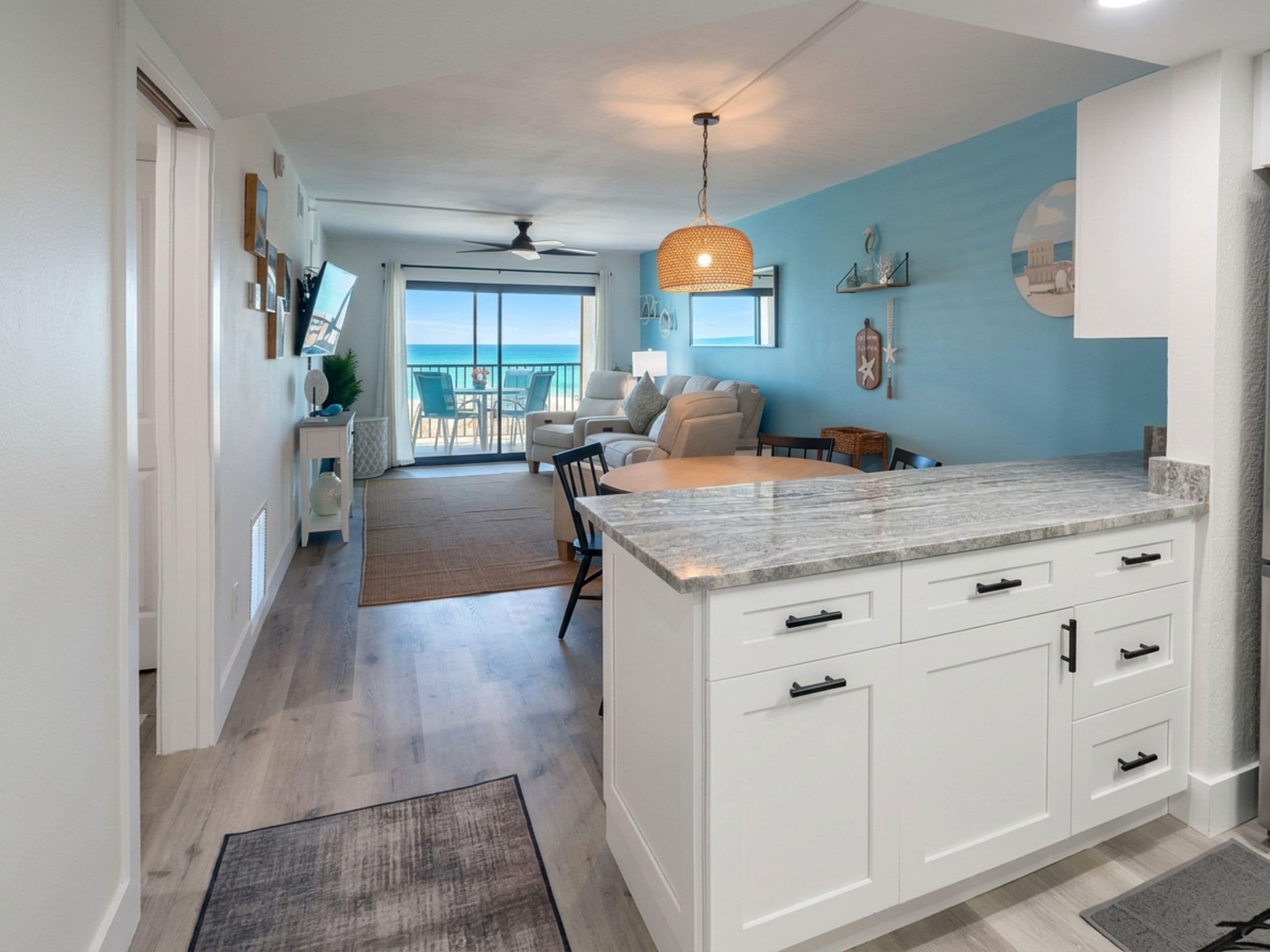 Una cocina moderna con muebles blancos, una isla grande y vistas al exterior.