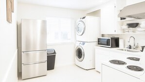 Una cucina moderna con elettrodomestici in acciaio inossidabile, un forno a microonde e un lavello.