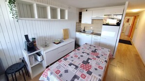A compact kitchenette with a built-in stove, a small sink, and white cabinetry.