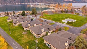 A residential area with houses, a parking lot, and a lake in the background. - Wapato Point Resort home with hot tub and views (Manson)