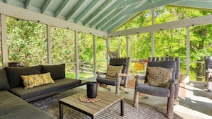 A covered outdoor seating area with a sofa, chairs, and a table. - Historic Barn Retreat w/ Pool & Pond Views Longview Pond Lodge by Avantstay (Clinton Corners)