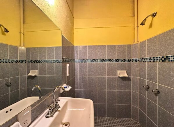 Un baño con bañera, lavabo y zona de ducha.