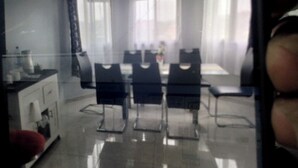 A dining area with a glass table and chairs, a white cabinet, and a window with sheer curtains. - Cameroon Comfort 2-bedroom apartment in peaceful Yassa with WiFi, AC, EspaceVert (Yassa)