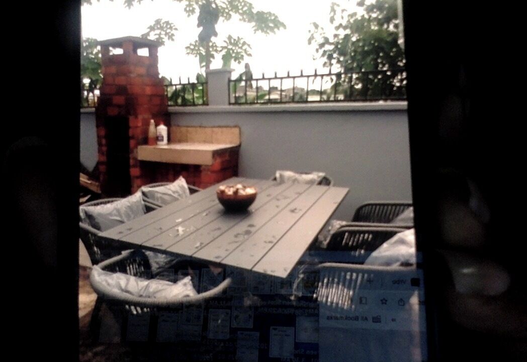 A patio area with a table, chairs, and a brick structure.