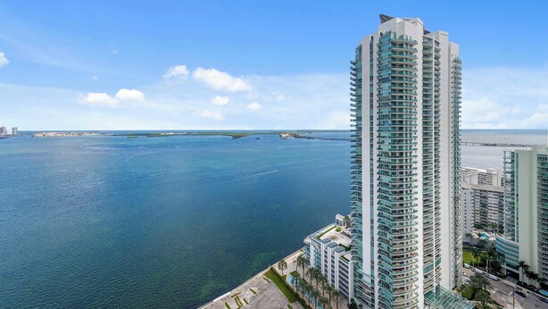 A high-rise hotel with a view of the ocean and a bridge in the distance. - Luxury Brickell Penthouse Ocean Views Rooftop Pool (Miami)