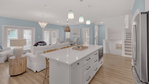 A modern kitchen with white cabinetry, a central island, and pendant lighting. - 4BR Home w/ Private Pool, Game Room, Beach Access! (Santa Rosa Beach)