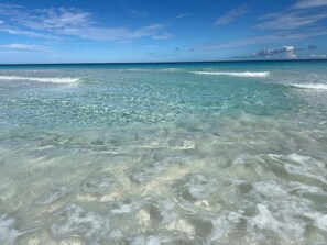 Une vue dégagée sur une plage aux eaux turquoise et aux vagues douces.