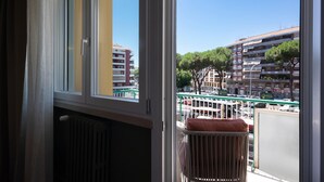 Vista desde una ventana, con un radiador y una silla de mimbre afuera.