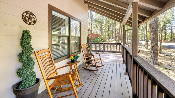 A wooden porch with two rocking chairs and a potted plant. - Grill & Games: Family-Friendly Flagstaff Getaway! (Flagstaff)