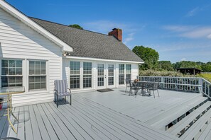A white house with a covered deck, large windows, and a chimney. - 78-Acre Retreat Near Campbell U: Fish, Play, Relax (Coats)