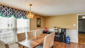 A dining area with a wooden table, beige chairs, a coffee machine, and a water cooler. - 78-Acre Retreat Near Campbell U: Fish, Play, Relax (Coats)