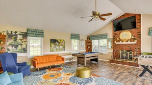 A spacious living room with a pool table, a blue sofa, an orange sofa, and a colorful rug. - 78-Acre Retreat Near Campbell U: Fish, Play, Relax (Coats)