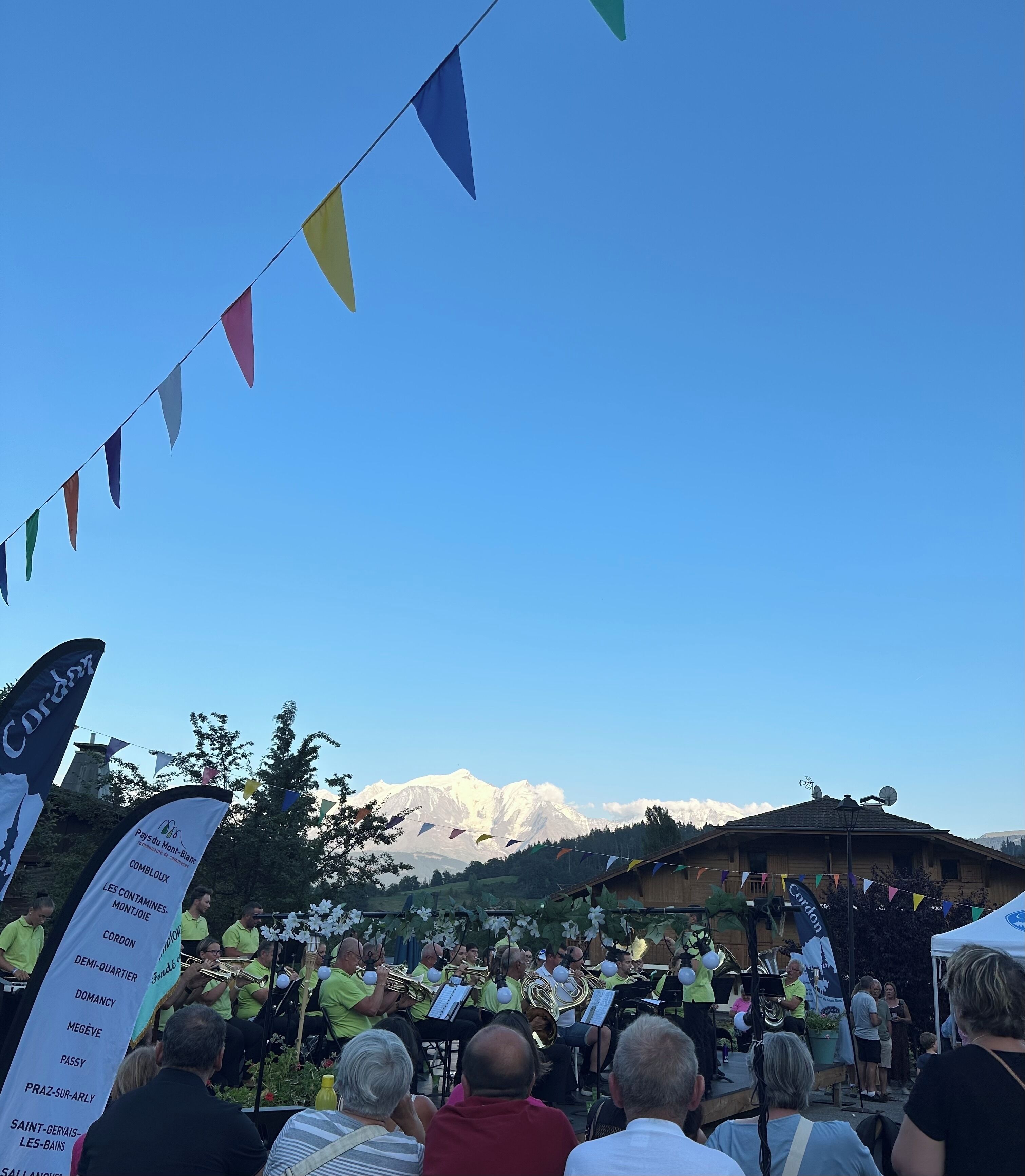A group of people watching a performance with a mountainous backdrop.