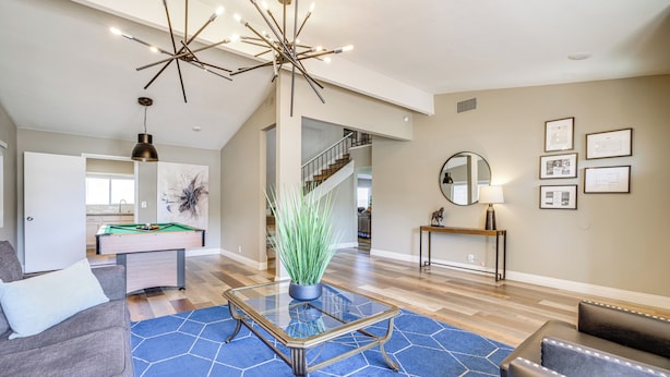 A spacious living room with a pool table, a blue rug, and a modern chandelier. - Quiet Henderson Retreat: Extended Stays & Gazebo! (Henderson)