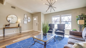 A spacious living room with a blue rug, a round mirror, a coffee table, and two armchairs. - Quiet Henderson Retreat: Extended Stays & Gazebo! (Henderson)