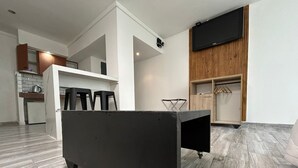 A modern kitchen with a built-in oven, a wooden cabinet, and a black countertop. - Suites Lima (Buenos Aires)