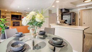 Una cocina moderna con microondas integrado, refrigerador y lavamanos.