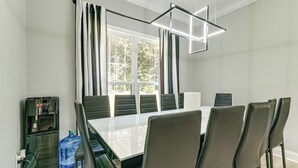 Ein Konferenzraum mit großem Tisch, Stühlen, Wasserspender und großer Wasserflasche.