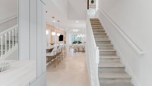 A modern interior with a staircase, a dining area, and a kitchen. - Amazing 7 bd Summerkitchen Gameroom (Clermont)