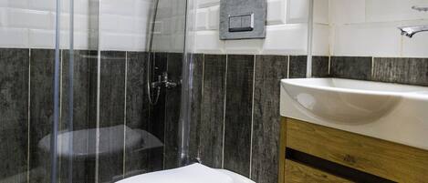 A bathroom with a shower, toilet, and sink.