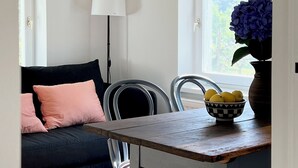 A cozy room with a dark blue sofa, a wooden table, and a window with a view of greenery. - Maria's Orchard Cottage - Nature vacation in Slovenia (Rogaška Slatina)