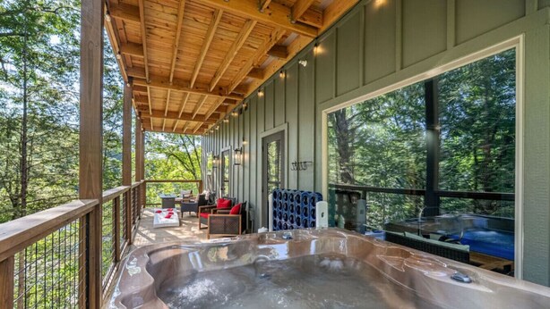 A hot tub on a wooden deck with a view of the forest.