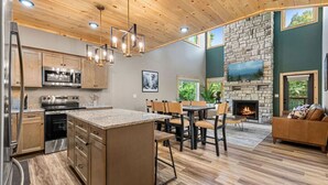 A modern kitchen with granite countertops, stainless steel appliances, and a central island.