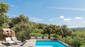 A pool with lounge chairs, surrounded by lush greenery and a mountainous backdrop. - Villa Elena - Charming Oasis with heated pool (Sardegna)