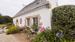 A white building with stone window frames and a tiled roof.