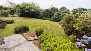 A well-maintained garden with a stone pathway leading to a house.
