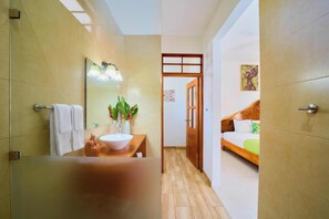 Casa de banho com lavatório, espelho e porta-toalhas.
