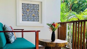 A balcony with a wooden table and a green sofa. - Olinca Boutique Hotel (Cahuita)