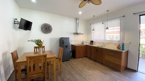 A modern kitchen with wooden cabinets, a built-in microwave, and a stainless steel refrigerator. - Olinca Boutique Hotel (Cahuita)