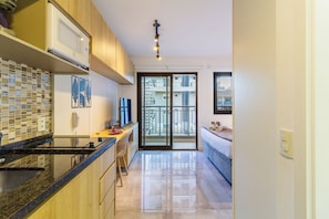 Una cocina moderna con microondas, estufa y salpicadero de azulejos.