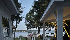 A deck with a grill and outdoor seating, overlooking a body of water. - LAKEFRONT GARDEN COTTAGE- beach, screened porch, dock, private, amazing views (Lake Norman of Catawba)