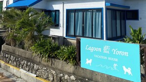 A building with a blue roof and a sign that reads "Lagoon Yoron Vacation House".