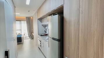 Una cucina moderna con mobili in legno, un frigorifero in acciaio inossidabile e una finestra che offre luce naturale.