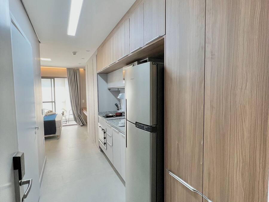 Una cucina moderna con mobili in legno, un frigorifero in acciaio inossidabile e una finestra che offre luce naturale.