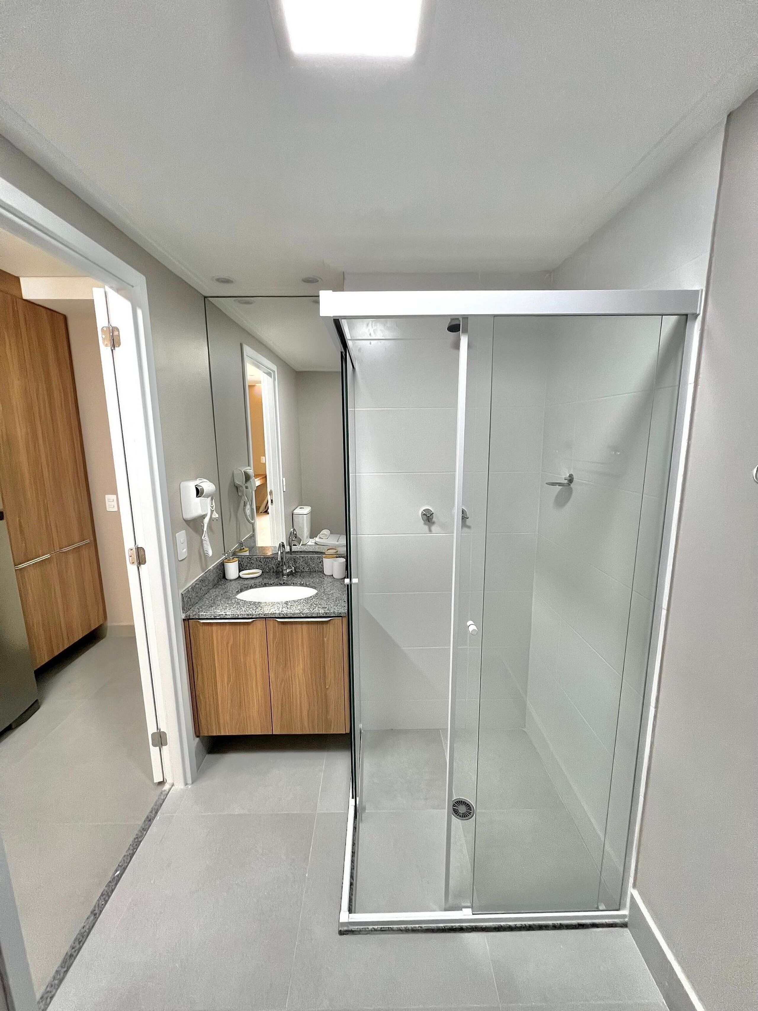 A modern bathroom with a shower, a sink, and a vanity.