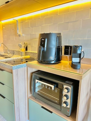 A compact kitchenette with a coffee maker, a toaster, and a microwave.