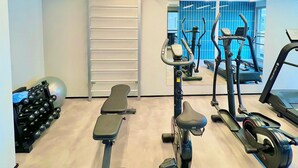 A gym with exercise equipment, a bench, and a mirrored wall. - La Vida (São Paulo)