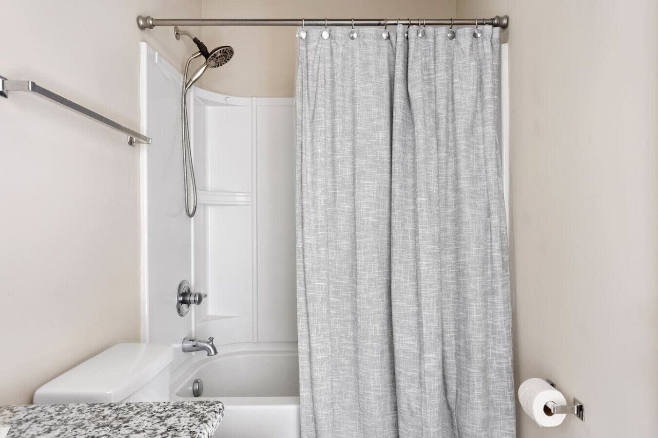 Une salle de bain équipée d’une douche, de toilettes et d’un porte-serviettes.