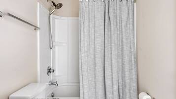 Une salle de bain équipée d’une douche, de toilettes et d’un porte-serviettes.