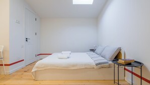A bedroom with a bed, a small table, a chair, a window, and a door. - Cozy studio with WiFi and AC in charming T'bilisi (T'bilisi)