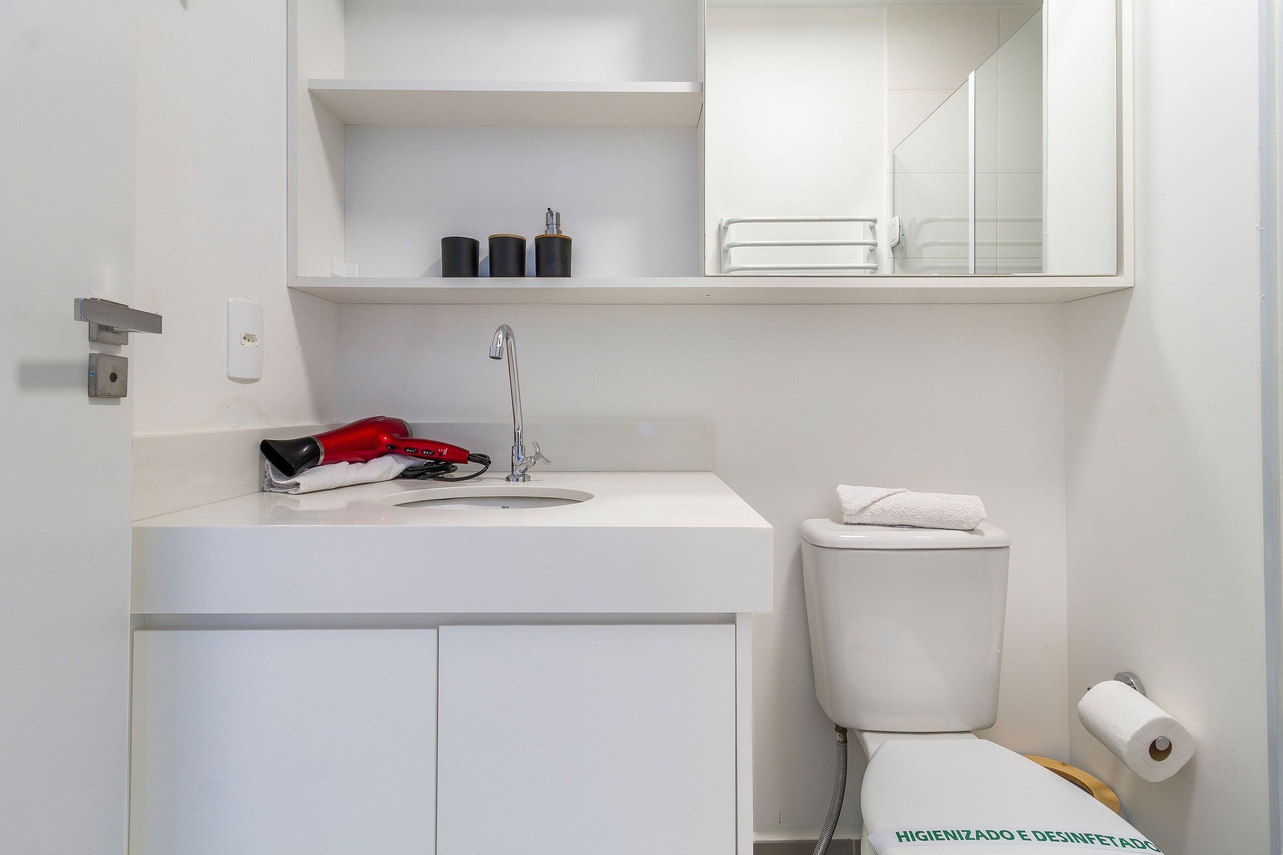 A bathroom with a white sink, a toilet, and a mirror above the sink.