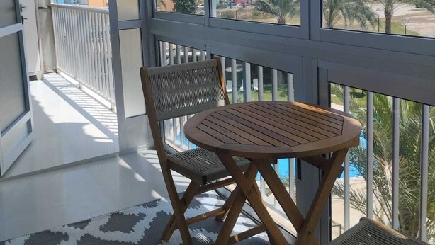 Ein Balkon mit Blick auf den Strand und Palmen.
