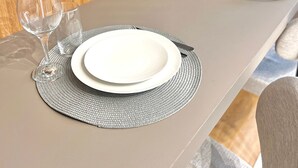 A neatly set dining table with two plates, two wine glasses, and a fork. - Innvista -Trends Brooklin. (São Paulo)