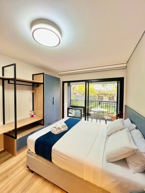 A modern hotel room with a large bed, a desk, and a balcony with a view. - Innvista -Trends Brooklin. (São Paulo)
