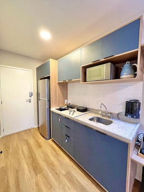 A modern kitchen with a refrigerator, microwave, kettle, and sink. - Innvista -Trends Brooklin. (São Paulo)