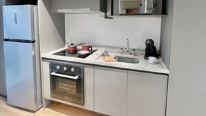 A modern kitchen with a built-in oven, microwave, and a coffee maker on the countertop. - Innvista -Trends Brooklin. (São Paulo)